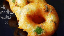 a close up of a doughnut with the words hi medhu vadai written on the bottom