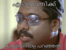 a man wearing sunglasses and a red shirt has a caption in malayalam