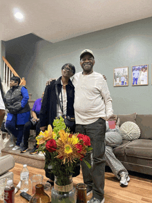 a man and a woman pose for a picture in a living room