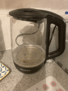 a black prolex electric kettle sits on a counter