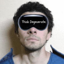 a man wearing a virtual reality goggles that say think degenerate