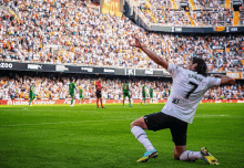 a soccer player with the number 7 on his jersey kneeling on the field