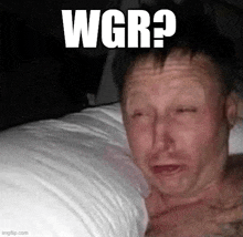 a man is laying on a bed with his eyes closed and a caption that says wgr ?