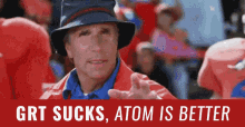 a man wearing a hat stands in front of a sign that says " grt sucks atom is better "