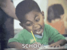 a young boy is sitting at a desk in a classroom with a pencil in his mouth and the word school is visible .