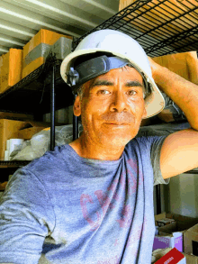 a man wearing a hard hat is standing in front of a shelf with boxes on it and a box that says zebra