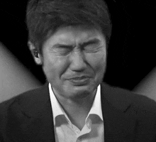 a black and white photo of a man in a suit crying