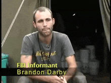 a man wearing a fbi informant brandon darby t-shirt