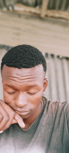 a young man with his eyes closed is wearing a black shirt