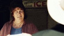 a woman smiles in front of a sign that says ice