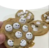 a person is holding a cookie with a face on it