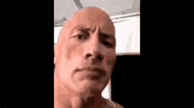 a close up of a bald man 's face with a serious expression .