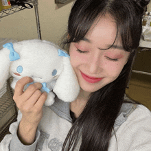 a girl holding a stuffed animal with a blue bow on its ear