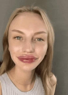 a close up of a woman 's face with a huge lip .