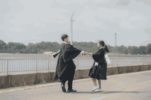 a man and a woman are dancing in front of a lake