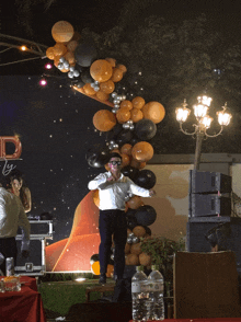 a man stands on a stage in front of a sign that says ' party '