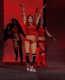 a female wrestler wearing a red shirt that says team belly