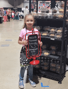 a little girl holds a sign that says bella mammas biscotti