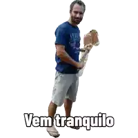 a man in a blue shirt is holding a stick and the words vem tranquilo are above him