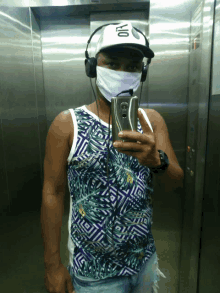 a man wearing a mask and headphones takes a picture of himself