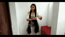 a woman with very long hair is standing in a hallway