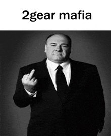 a man in a suit and tie is giving the middle finger with the words 2gear mafia below him