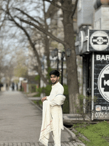 a man standing in front of a sign that says ks bar