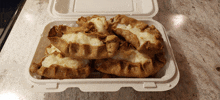 a plastic container filled with a few pastries on a counter