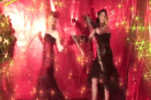 two women in dresses are dancing in front of a red background .