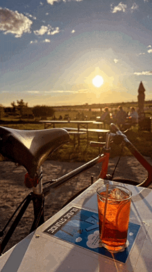 a bicycle sits on a table with a drink in front of it and a sticker that says " blue stump "