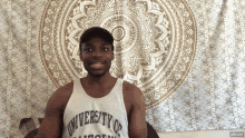 a man wearing a university of california tank top smiles