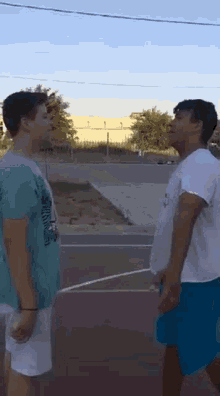 two boys standing next to each other on a basketball court with one wearing a shirt that says ' hawaii '