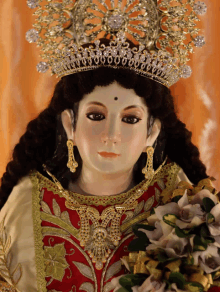 a statue of a woman wearing a gold tiara and earrings