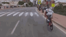 a man is riding a bike down a street with a yellow sign that says ' avenida ' on it