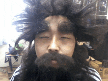 a man with a beard and a wig looks at the camera