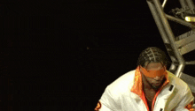 a wrestler with blindfolds on his eyes and a white jacket