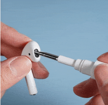 a person is holding a pair of white earbuds with a screwdriver