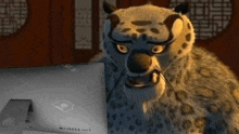 a cartoon leopard is sitting in front of a laptop computer .