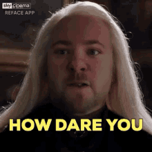 a man with long blonde hair and a beard is making a face and saying `` how dare you '' .