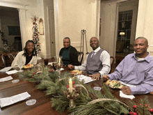 a group of people are sitting at a table with plates of food on it