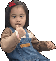 a little girl giving a thumbs up wearing overalls and a shirt that says hanscups