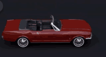 a red mustang convertible with the top down on a dark background