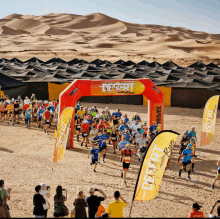 a group of runners are running under a desert banner