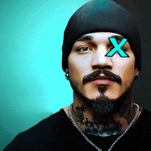 a man with a beard and a beanie has a blue x on his eye