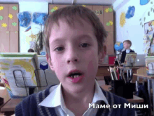 a young boy in a classroom with the word mame on the bottom right