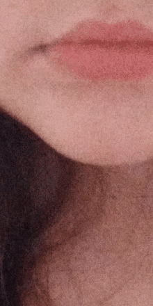 a close up of a woman 's lips with pink lipstick .