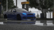 a blue sports car is parked in front of a gas station