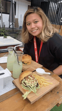 a woman sitting at a table with a lanyard around her neck that says ' abercrombie '