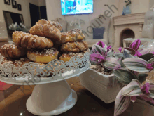 a stack of pastries sits on a white cake stand next to a plant