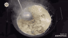 a pot of soup is being stirred with a spoon .